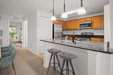 a kitchen with granite counter tops and a bar with stools