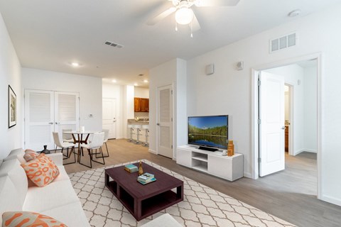 A living room with a white couch and a television.