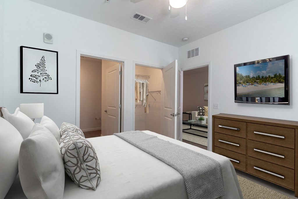 a bedroom with a large white bed and a tv