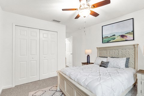 a bedroom with a bed and a ceiling fan