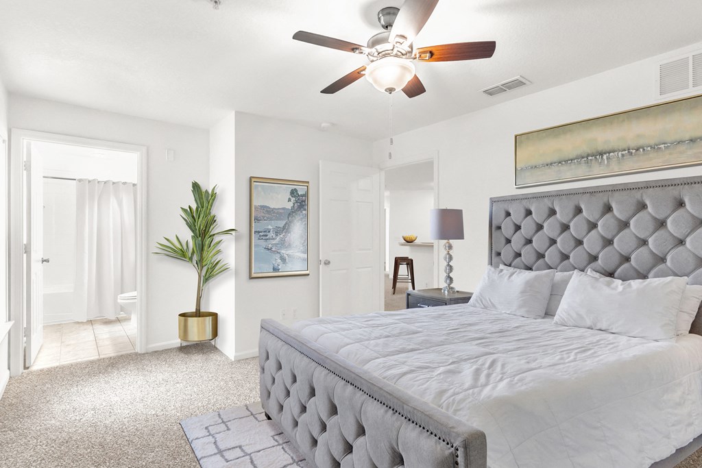 a bedroom with a large bed and a ceiling fan