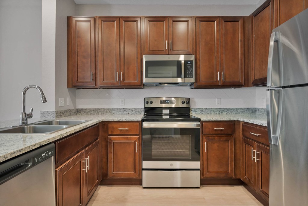 a kitchen with wooden cabinets and stainless steel appliances