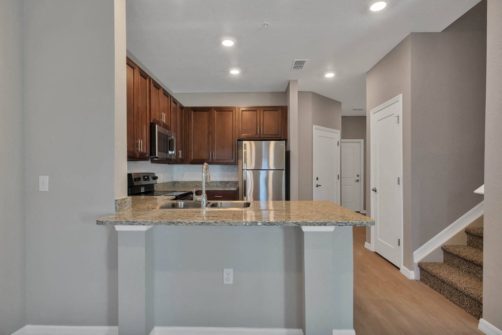 a kitchen with an island and stainless steel appliances