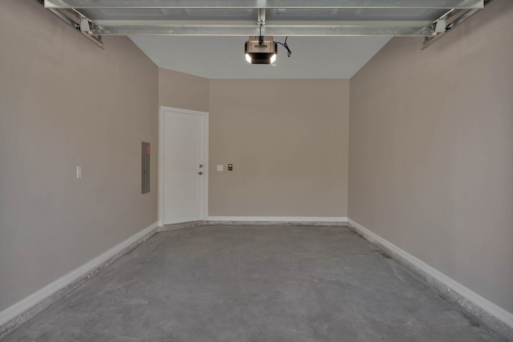 an empty room in a garage with a light on the ceiling