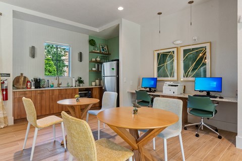 a dining room with a table and chairs and a kitchen with a desk and computer