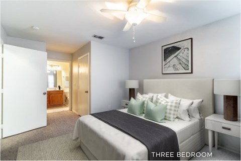 A bedroom with a bed, nightstand, and a ceiling fan.