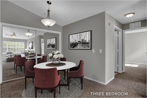 A dining room with a table set for six and a large window.