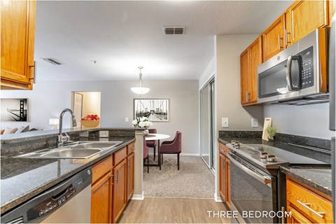 A kitchen with a dining table and chairs in the middle of the room.