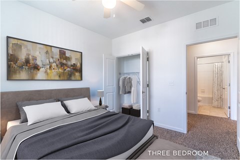 A bedroom with a bed, a painting on the wall, and a mirror.