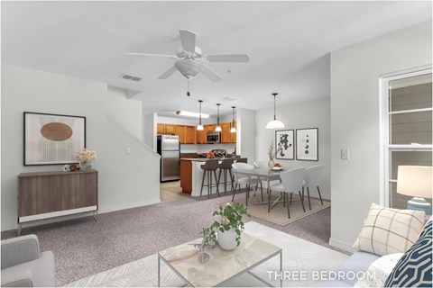 A well-lit, spacious three bedroom apartment with a kitchen and dining area.