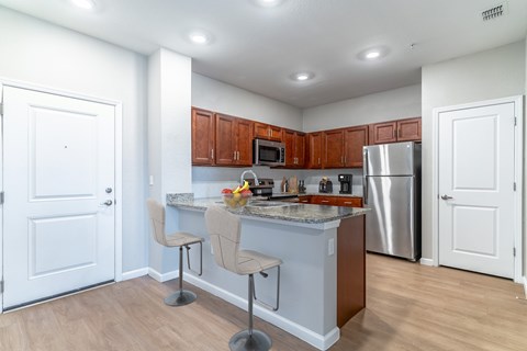 A kitchen with a white counter top and brown cabinets.