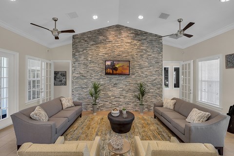 a living room with couches in front of a stone wall