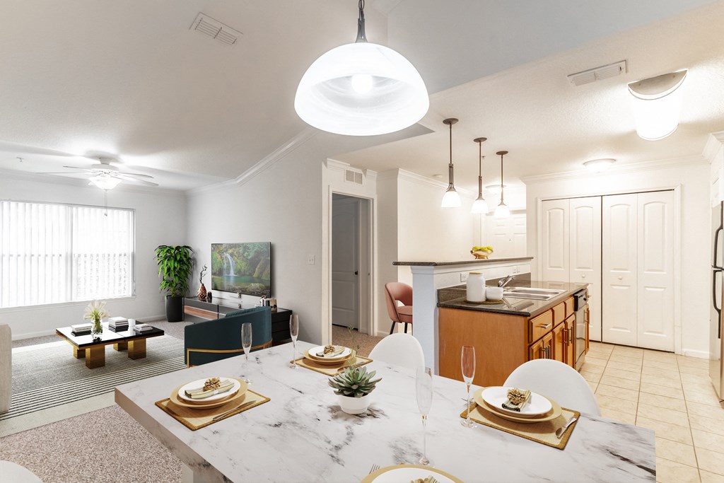 an open living room and dining room with a marble table and chairs and a kitchen