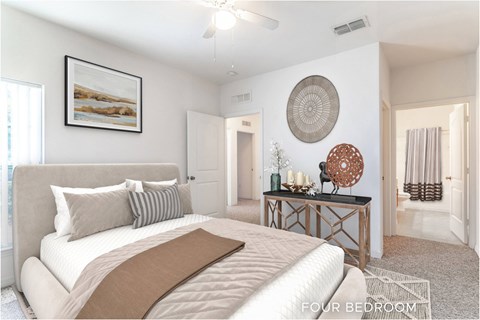A bedroom with a large bed and a painting on the wall.