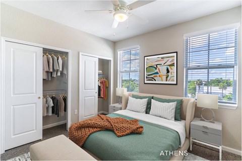 A bedroom with a bed, a ceiling fan, and a window with blinds.