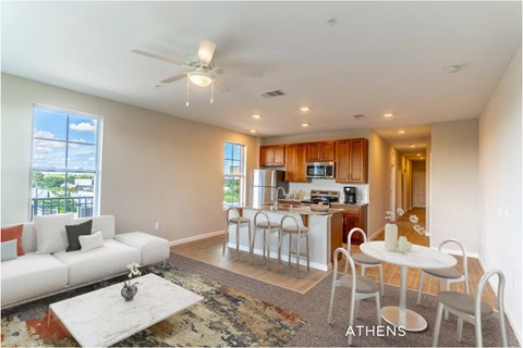 A spacious living room with a white couch and a rug.