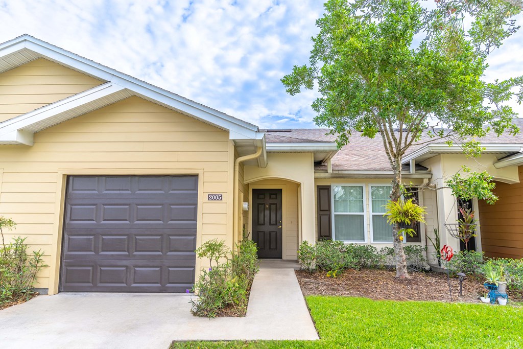 a yellow house with a black garage door