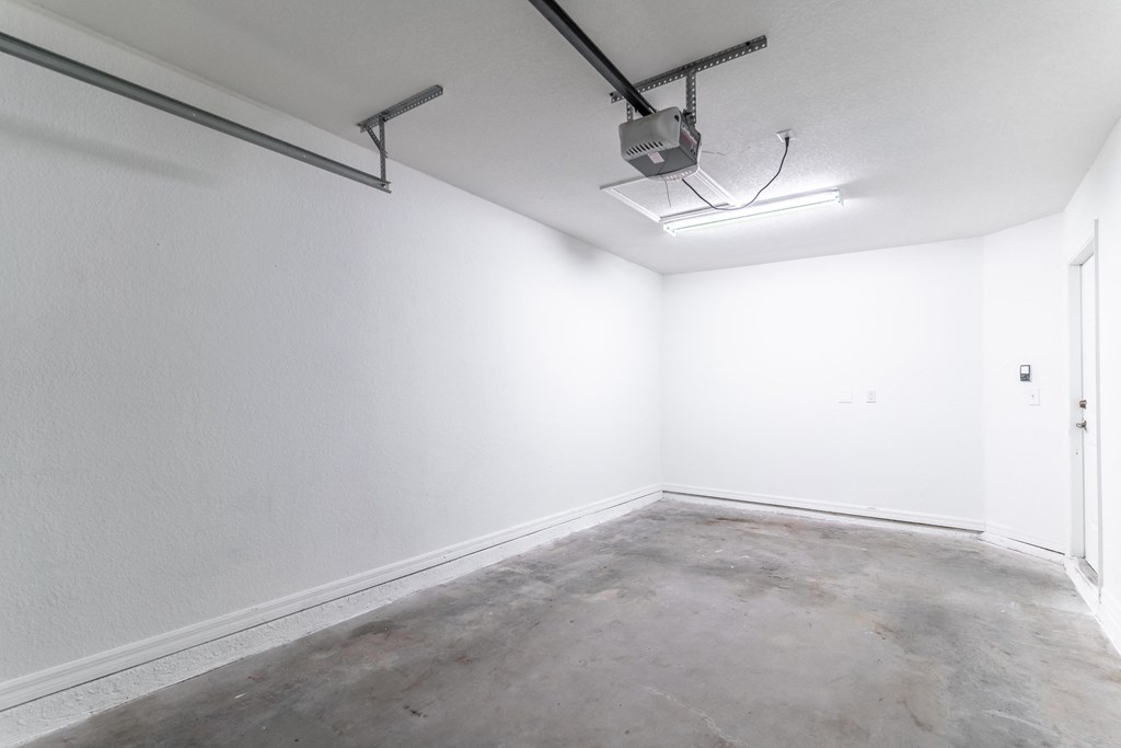 an empty room with white walls and a fluorescent light on the ceiling