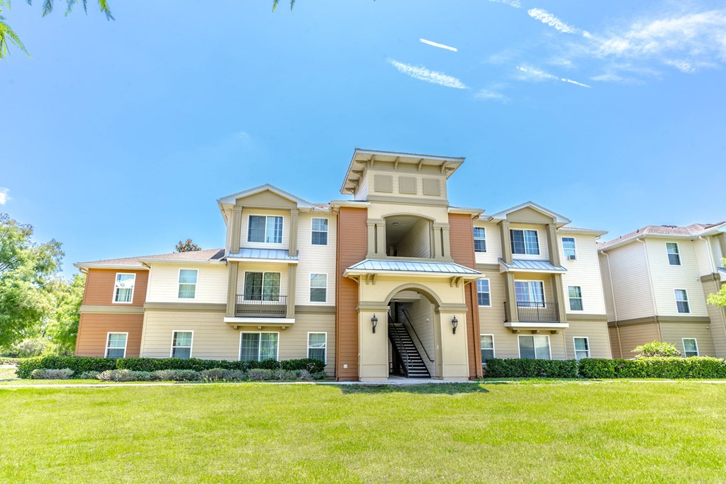 a large apartment building with a grassy area in front of it