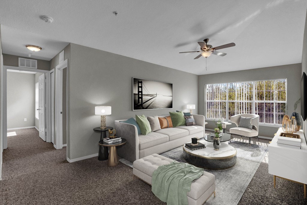 A living room with a white couch, a coffee table, and a ceiling fan.