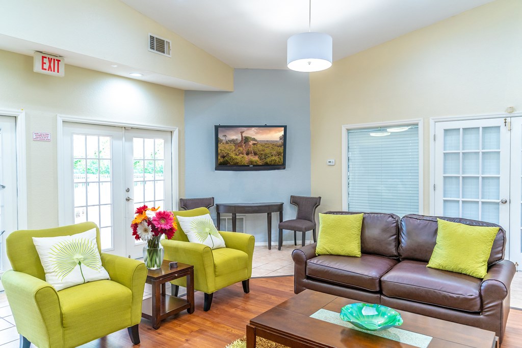 A living room with a brown couch, two yellow chairs, and a coffee table.