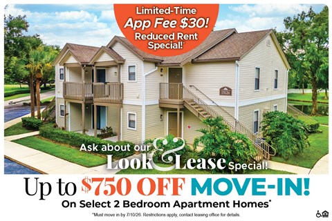 A large two-story apartment building with a sign offering a limited-time app fee free and a reduced rent special.