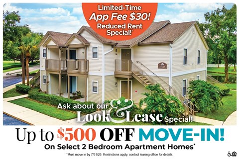 A large two-story apartment building with a sign offering a limited-time app fee free and a reduced rent special.