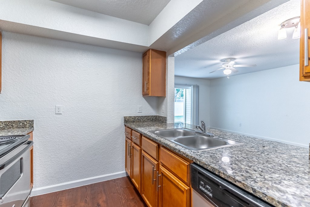a kitchen with granite countertops and wooden cabinets
