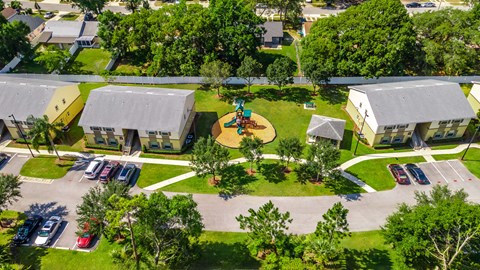 a birdseye view of a playground in the middle of a yard between two buildings