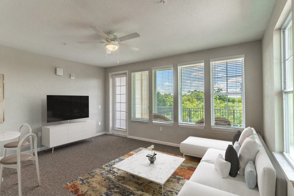 a living room with a white couch and a television