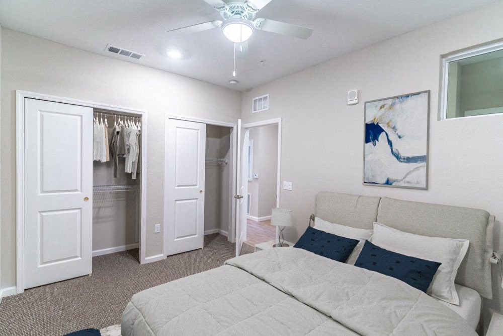 a bedroom with a large bed and a ceiling fan