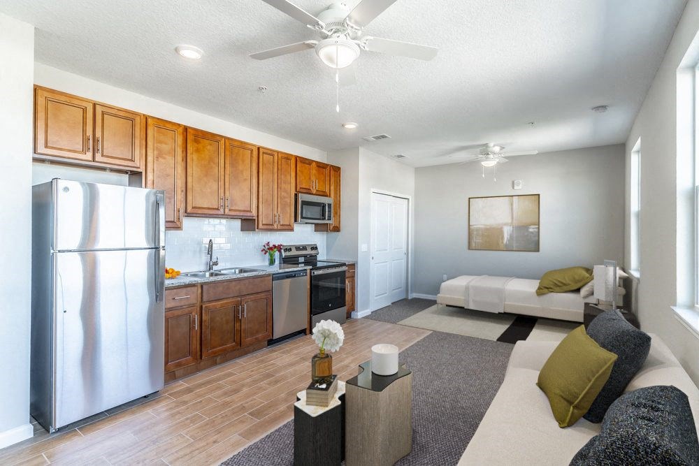 a kitchen and living room with a stainless steel refrigerator