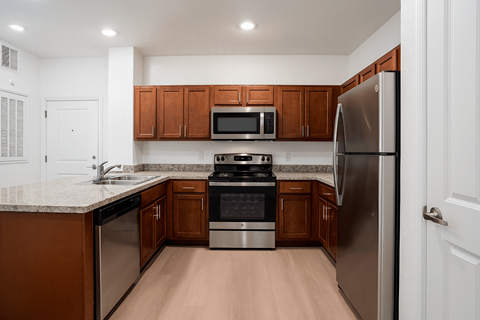 A kitchen with brown cabinets and stainless steel appliances.