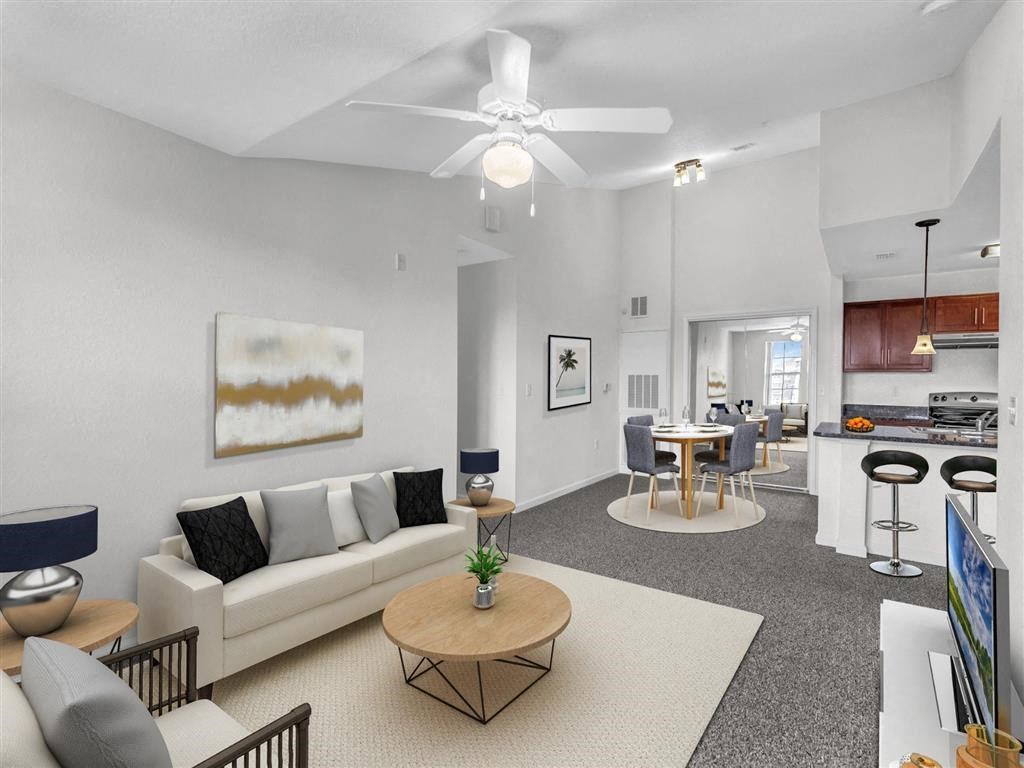 a living room with a couch a table and a ceiling fan