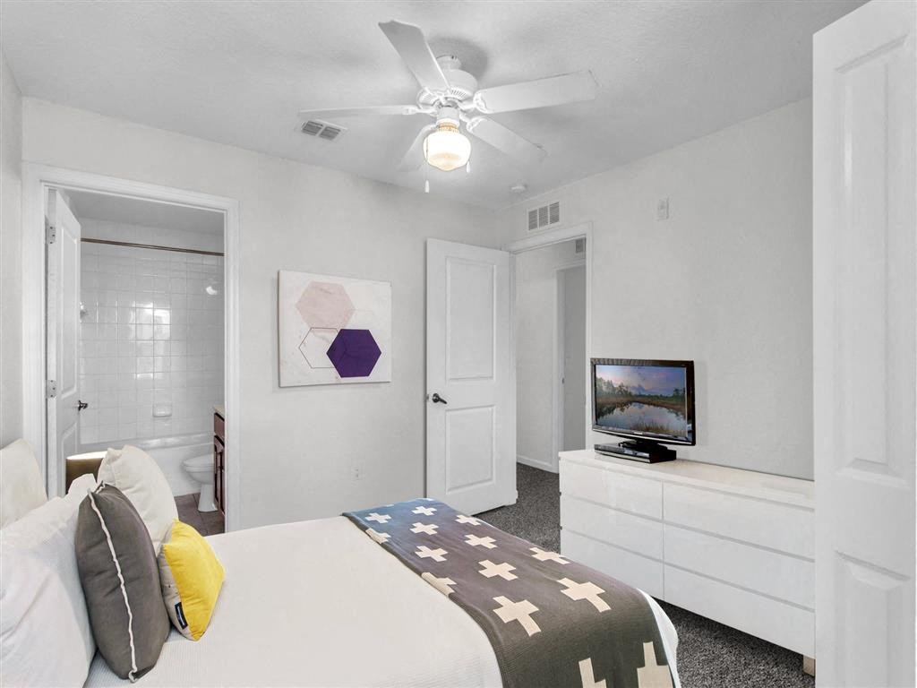 a bedroom with a bed and a ceiling fan