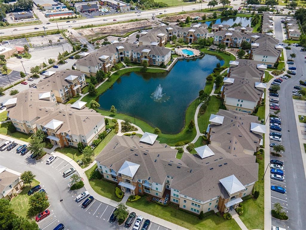 an aerial view of a community with a fountain in the middle of a lake