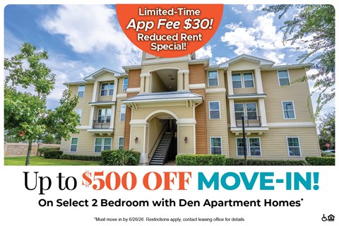 A large two-story apartment building with a red and white advertisement for a move-in special.