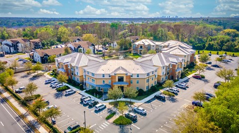 an aerial view of a large apartment complex with cars parked in the parking lot