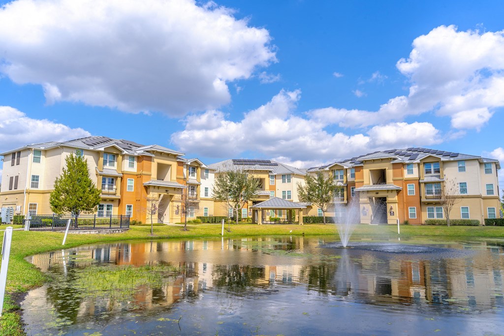a pond with a fountain in front of a building