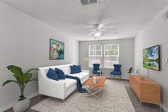 a living room with a white couch and blue chairs