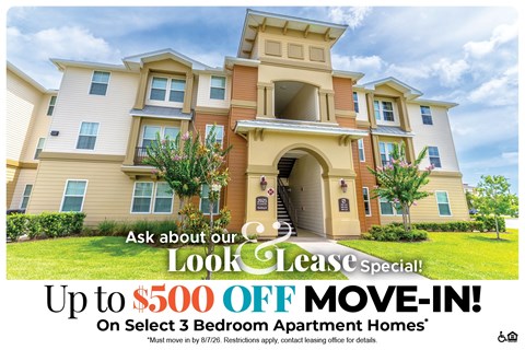 A large, multi-story apartment building with a sign offering a $500 off move-in deal.