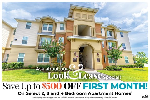 A large, multi-story apartment building with a sign offering a $500 discount on the first month.