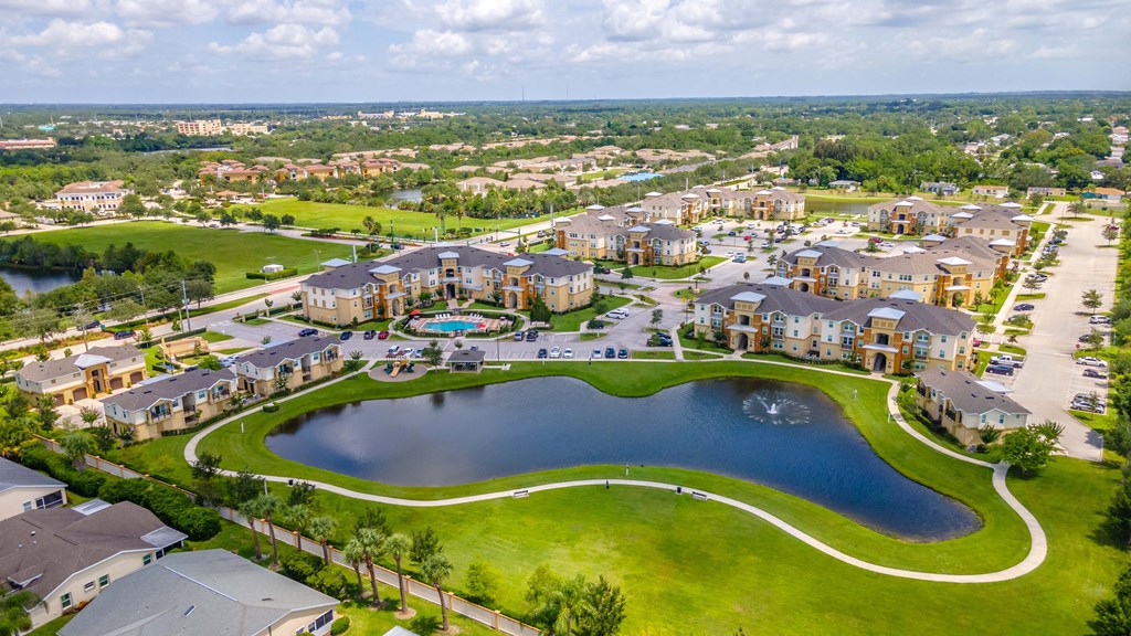 an aerial view of a community with a lake and a swimming pool
