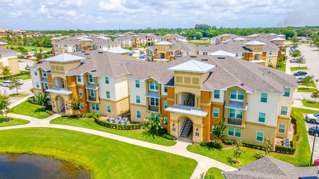 an aerial view of a large complex with a lake in front of it