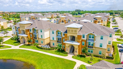 an aerial view of a large complex with a lake in front of it