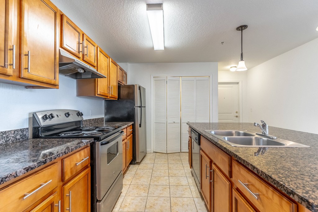 a kitchen with granite countertops and wooden cabinets