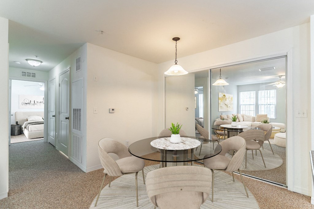 a dining room with a glass table and chairs