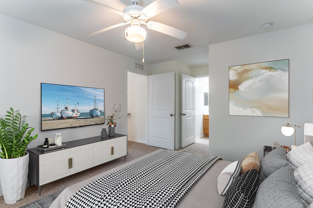 a bedroom with a large bed and a ceiling fan