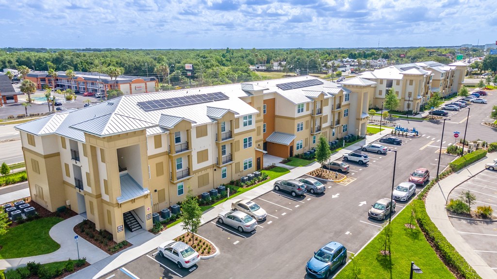an aerial view of a row of apartment buildings with cars parked in front of them
