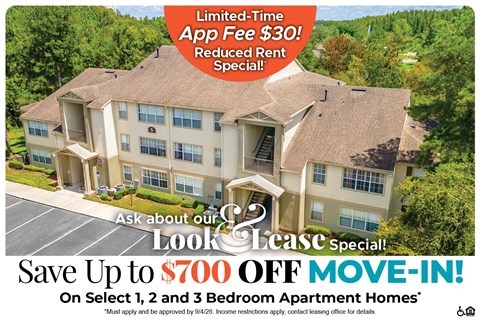 A large apartment complex advertises a limited-time app fee reduction and a move-in special.